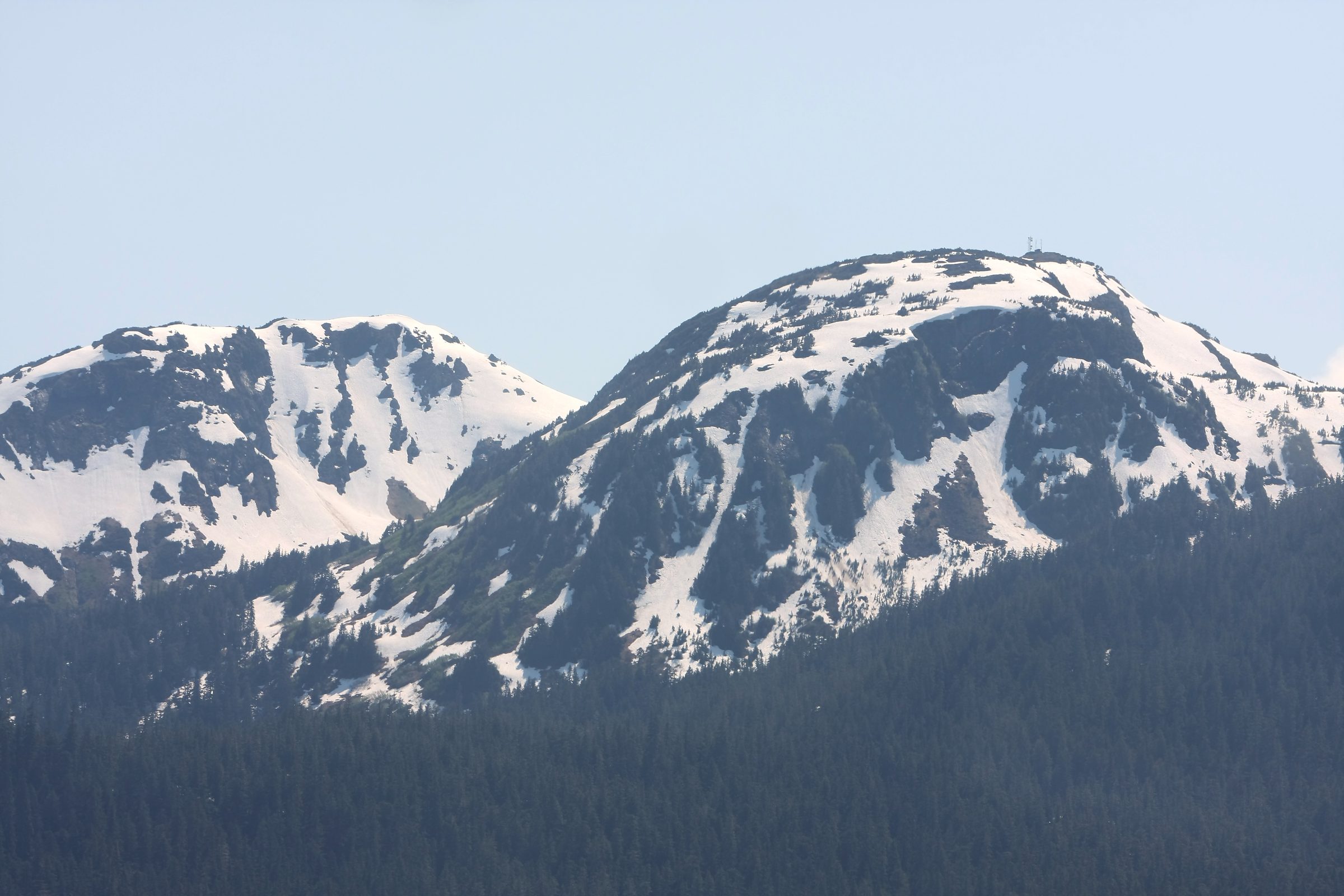 Twin snowy ridges against a clear blue sky.