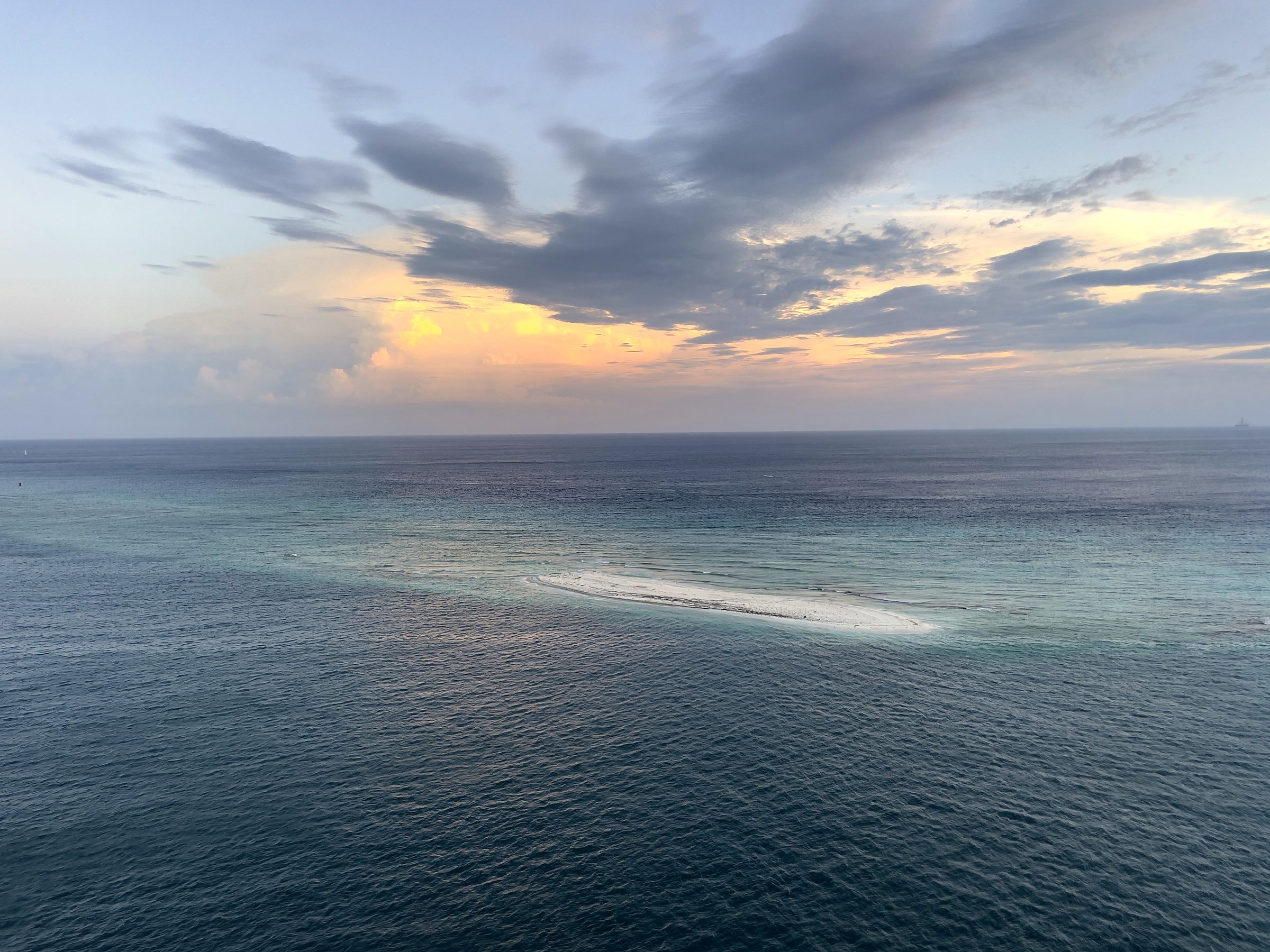 Calm dusk ocean with a single glowing brushstroke of light.