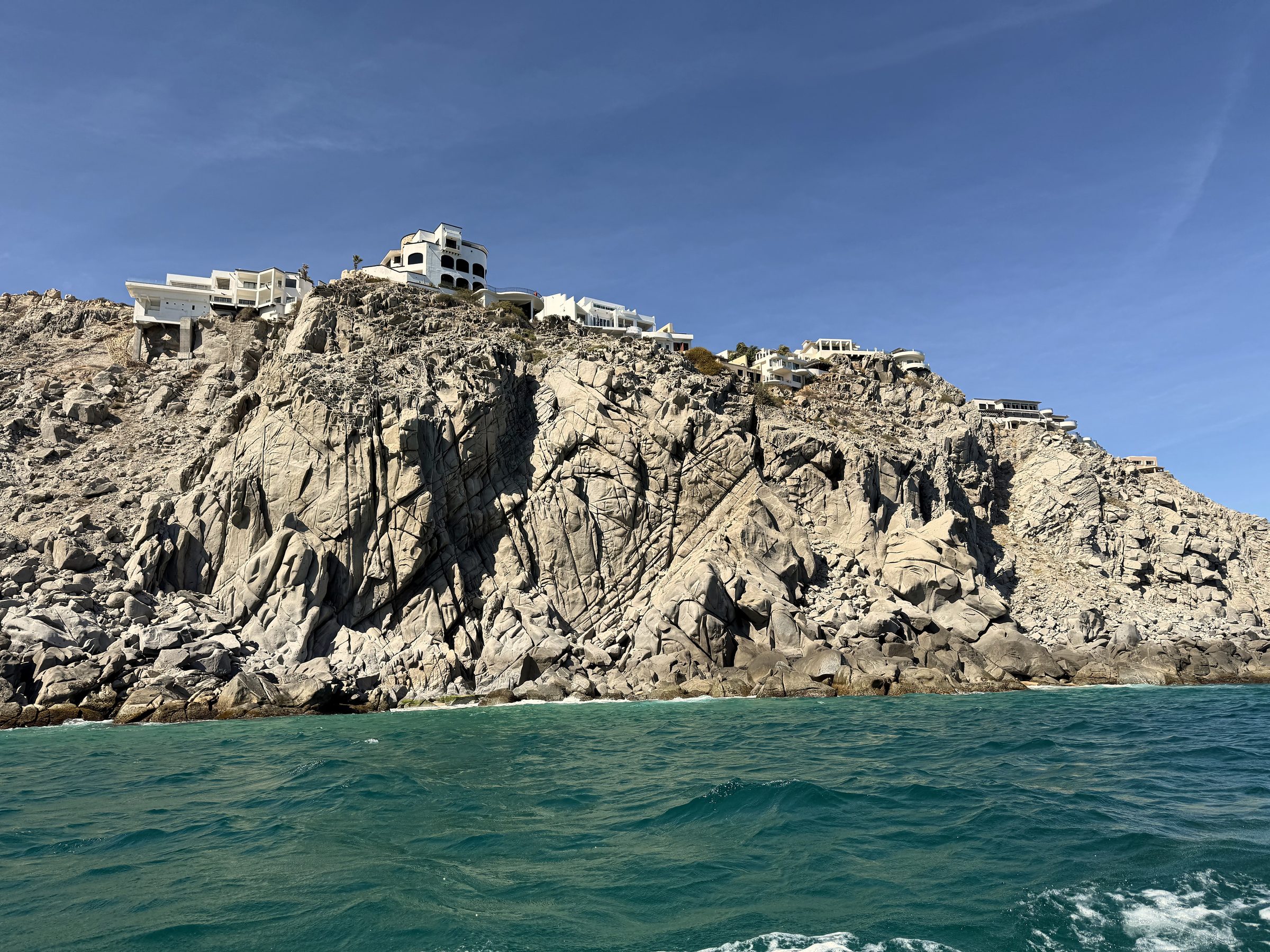 White lighthouse-like tower on a granite coastal spine.