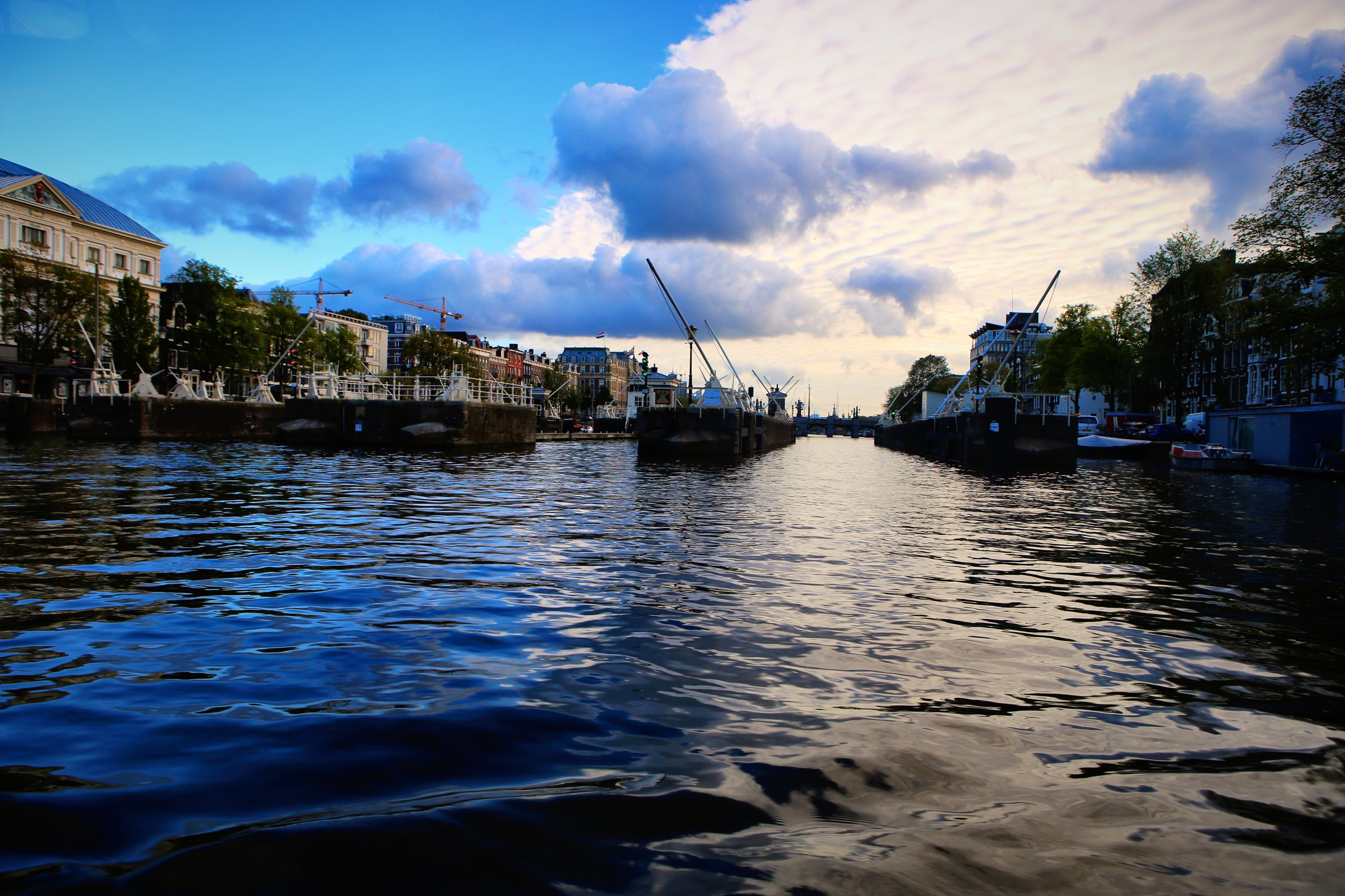 Wide canal water under dramatic clouds, seen from water level.