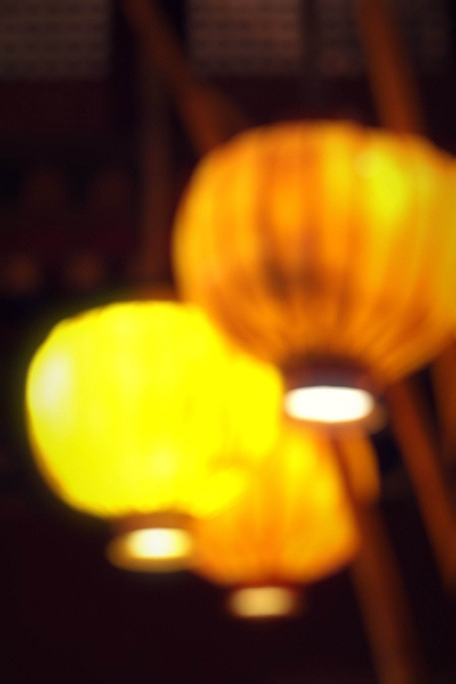 Glowing yellow lanterns softened against a dark background.
