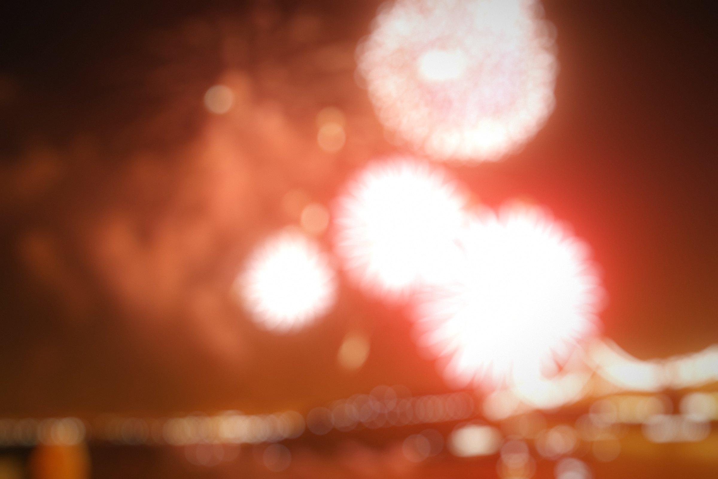 Red and white fireworks dissolved into soft glowing circles.