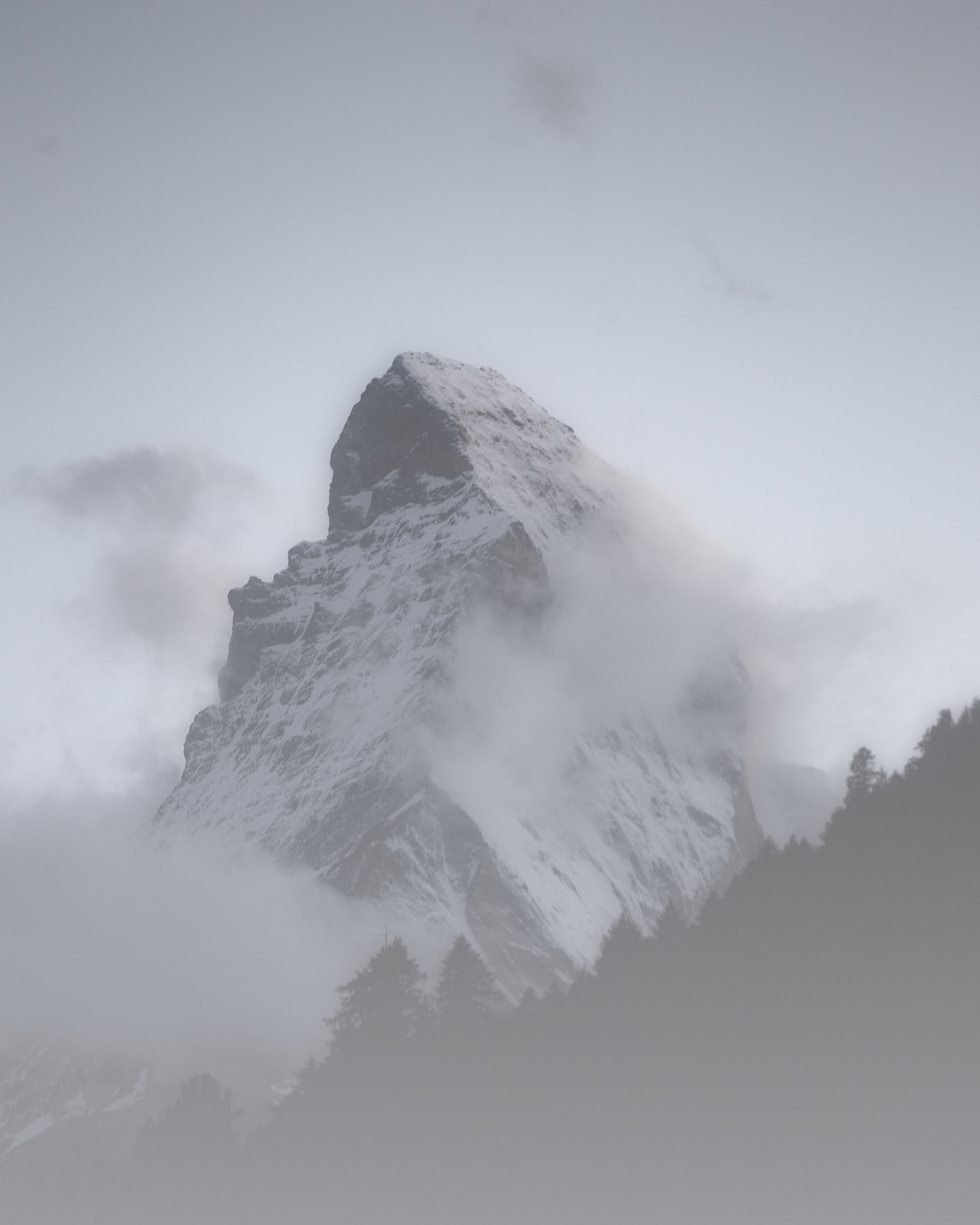 High-key misty image of the Matterhorn fading into pale cloud.