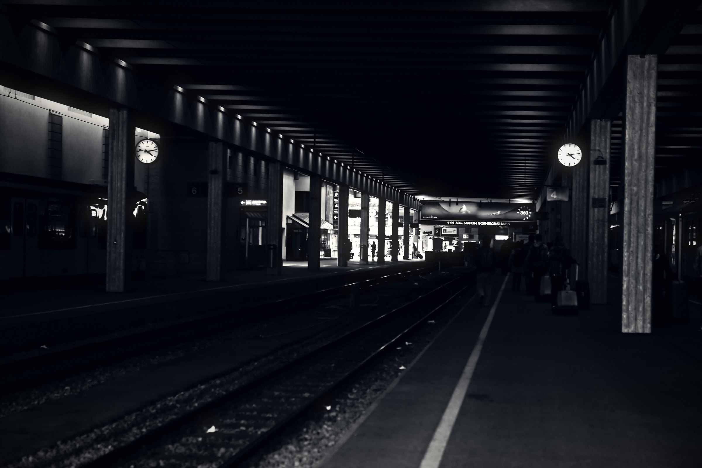 Long dark underground platform with a row of lights and columns.