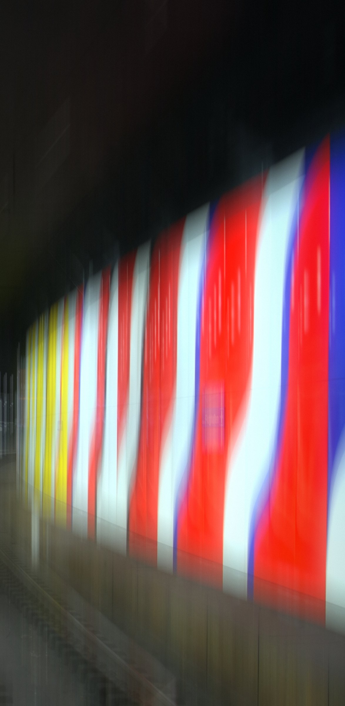 Vertical streaks of red, white, blue and yellow blurred into stripes.