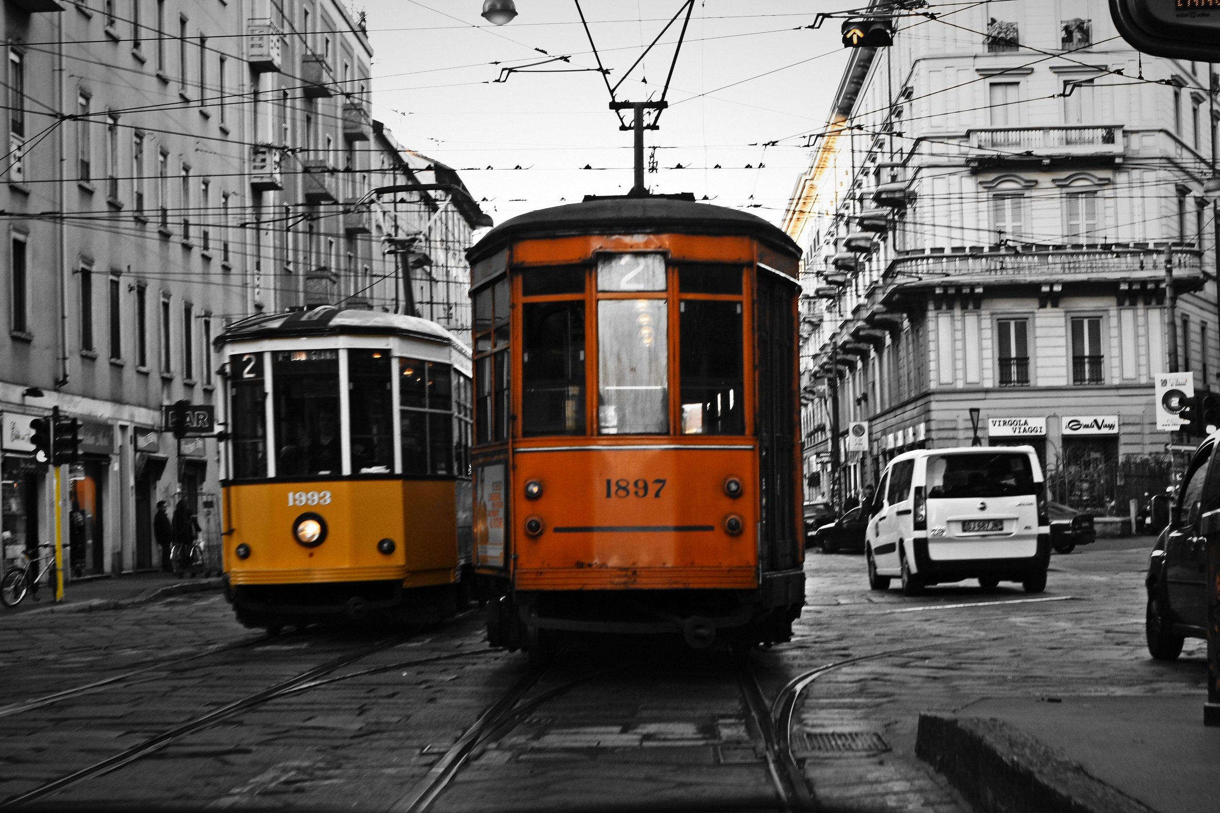 Black and white street with two vintage trams kept in bright orange.