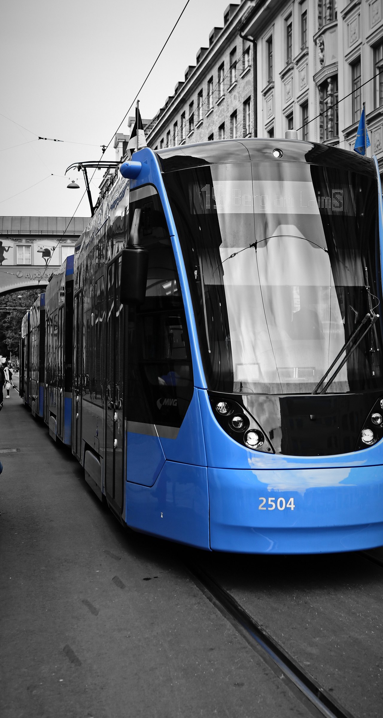 Black and white street with a modern tram kept in vivid blue.