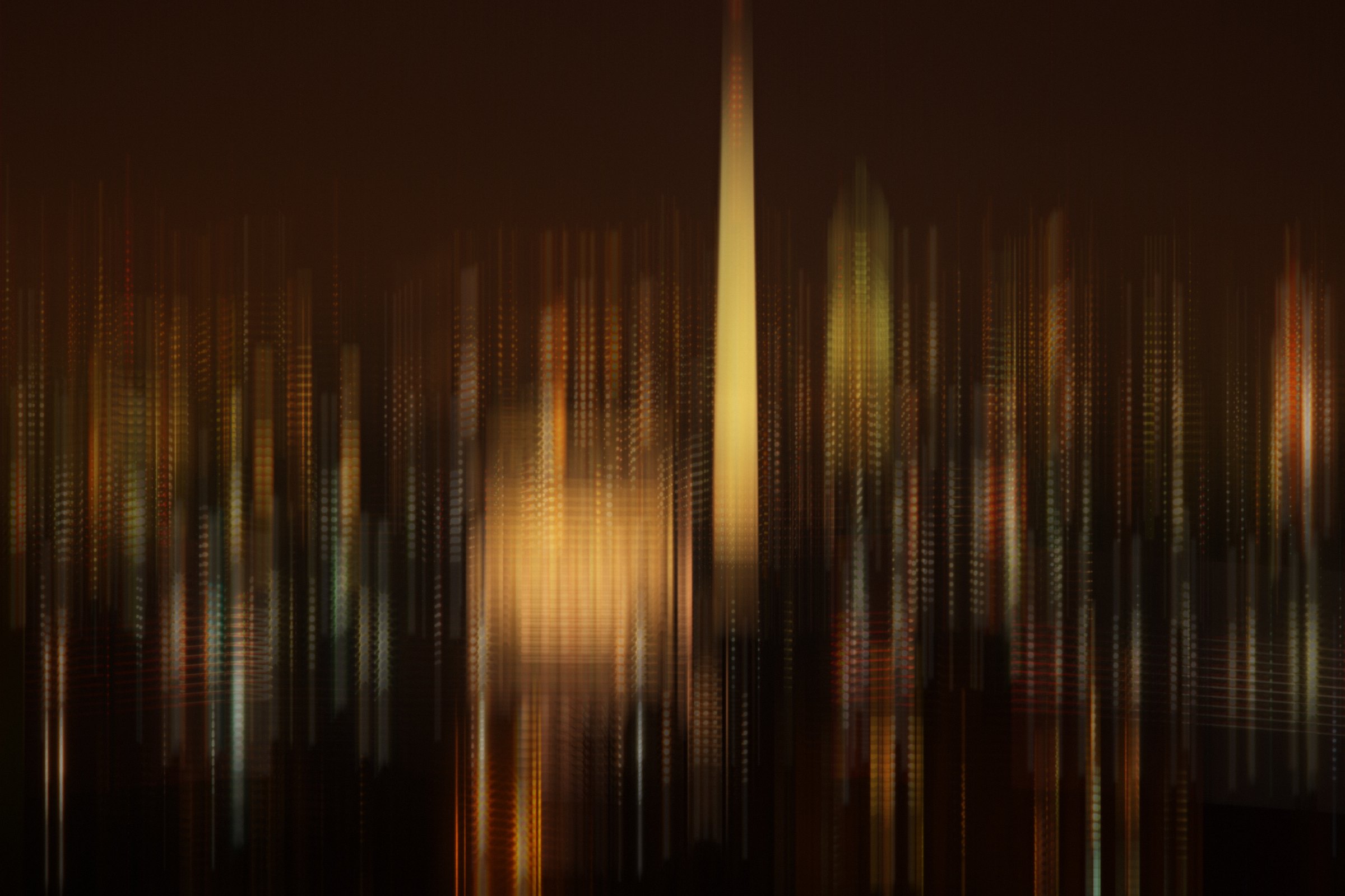 Vertical streaks of gold light rising out of darkness.