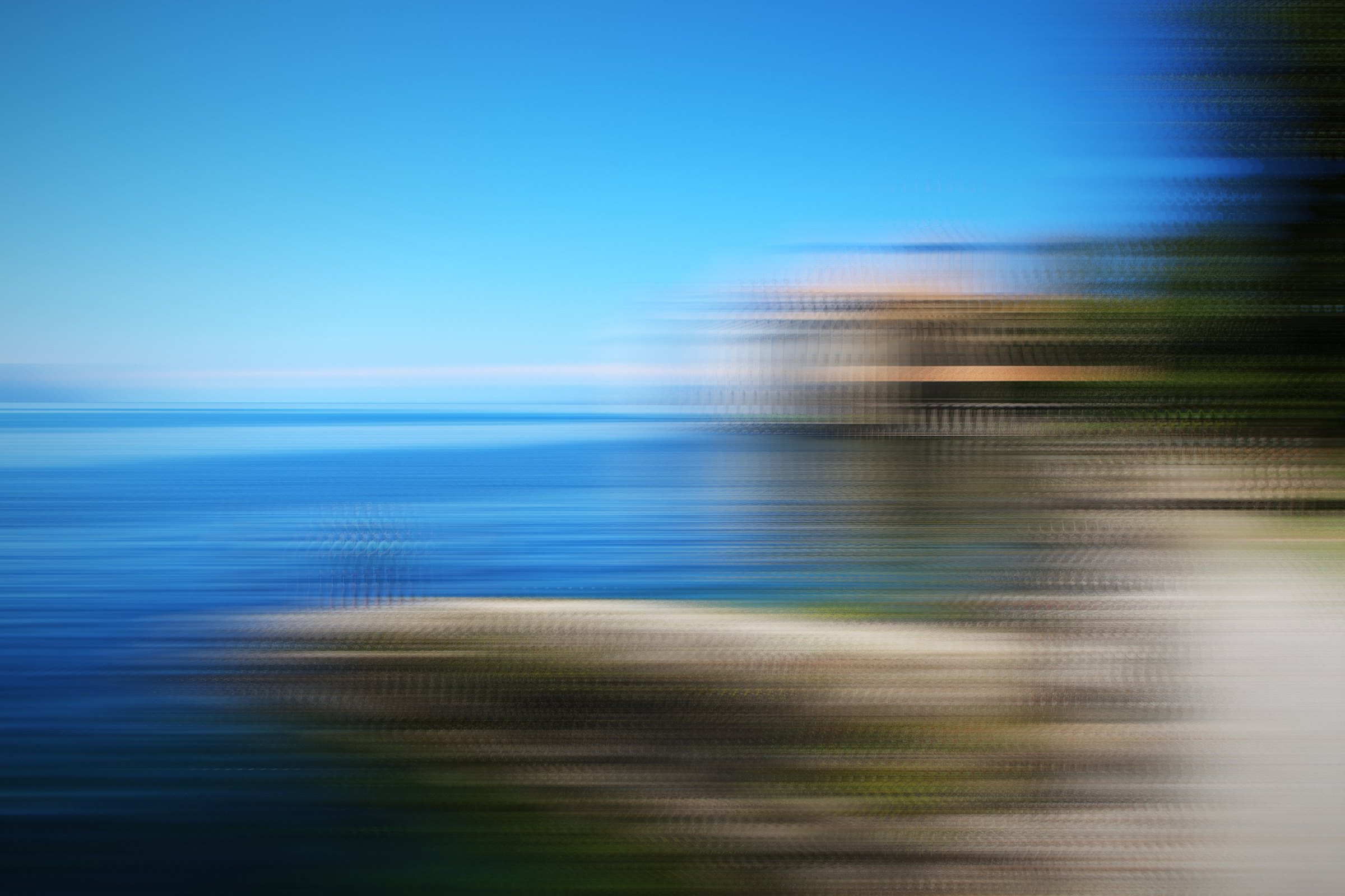 Horizontal streaks of turquoise water and a sunlit shore.