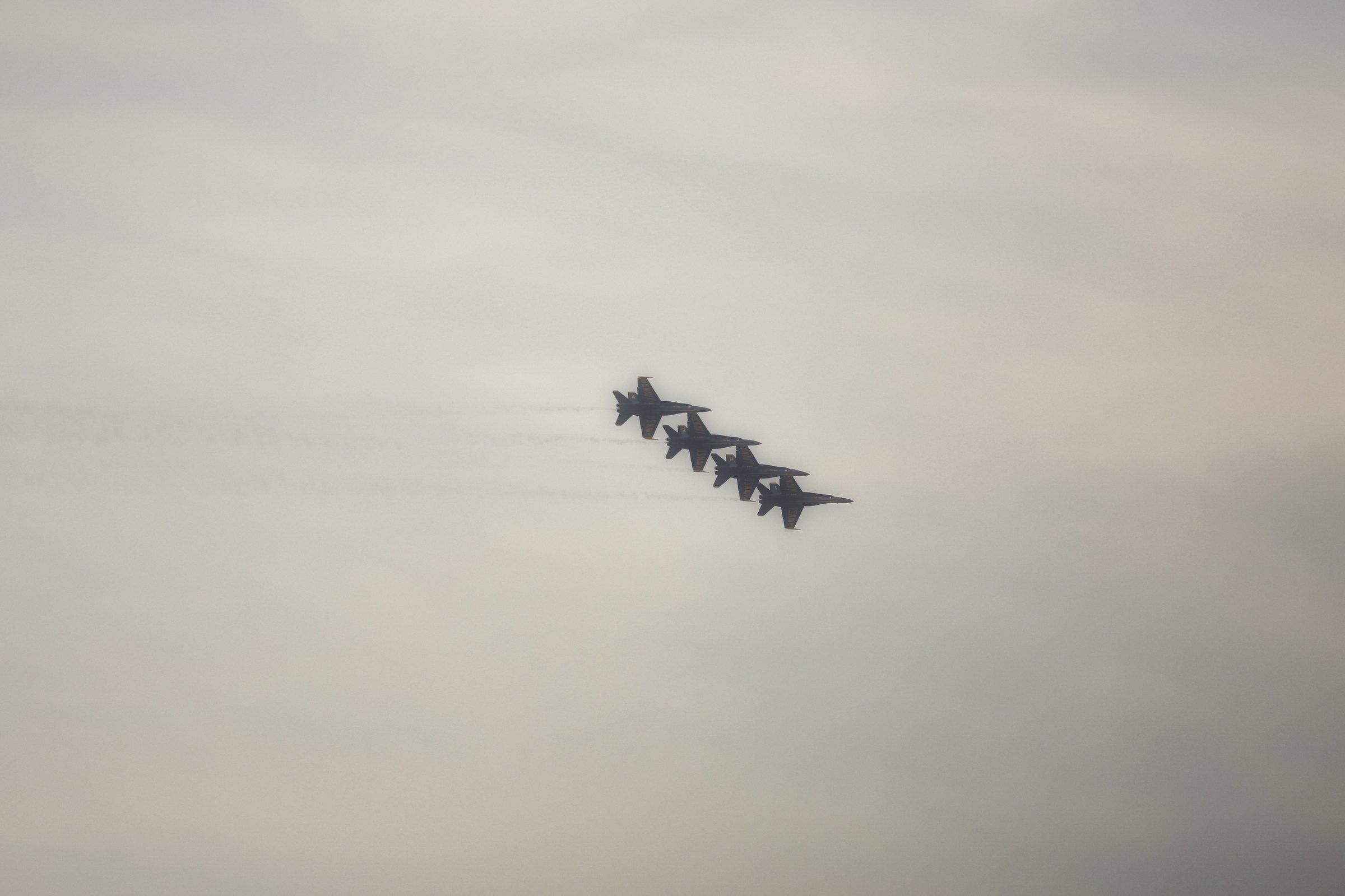 A tight formation of jets crossing a soft grey sky.