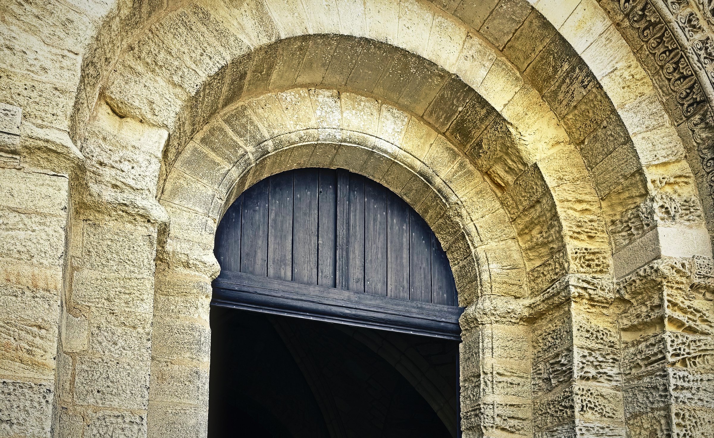 The carved concentric arches of a Romanesque church doorway in pale limestone.