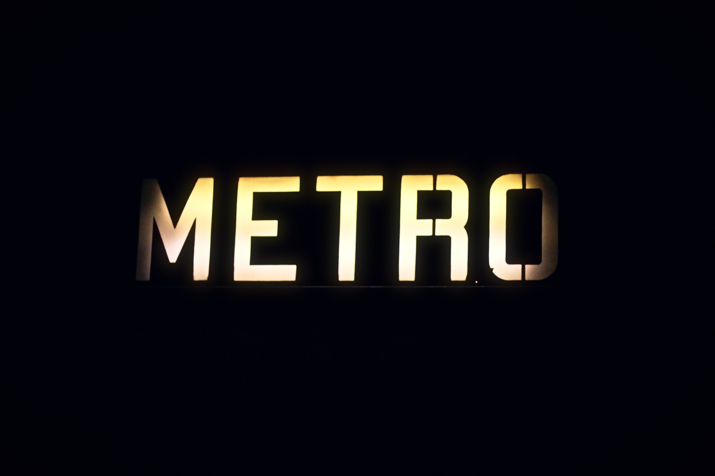 Backlit METRO letters glowing on black.