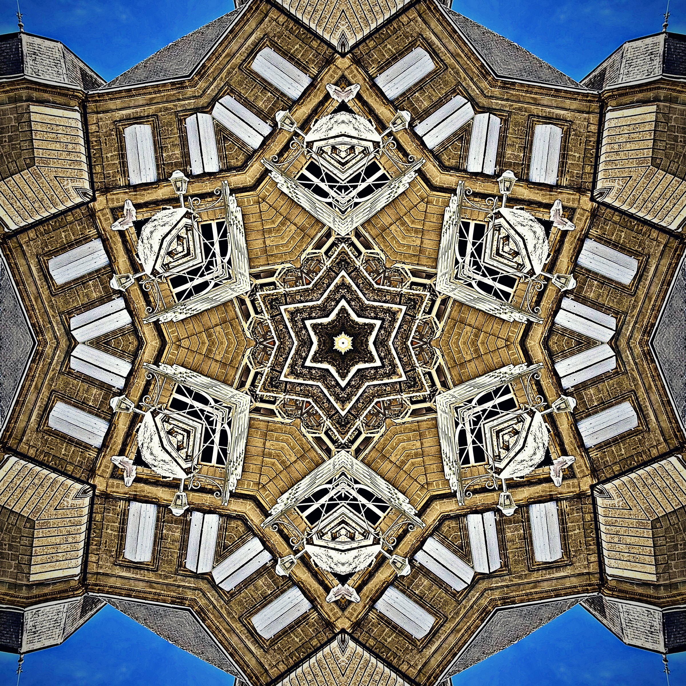 Gold and cream kaleidoscope of stonework and windows with a star at its center.