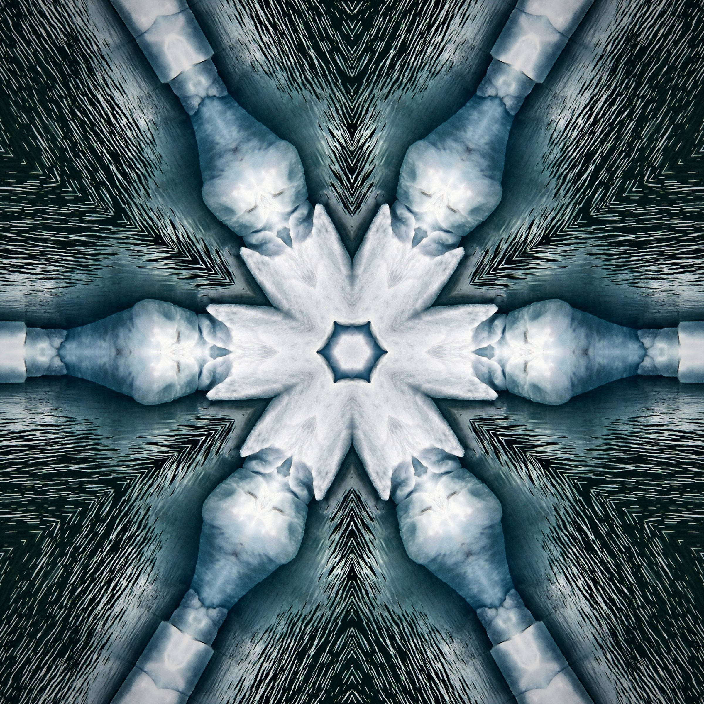 Kaleidoscope of blue-gray ice with a white six-pointed star in the middle.