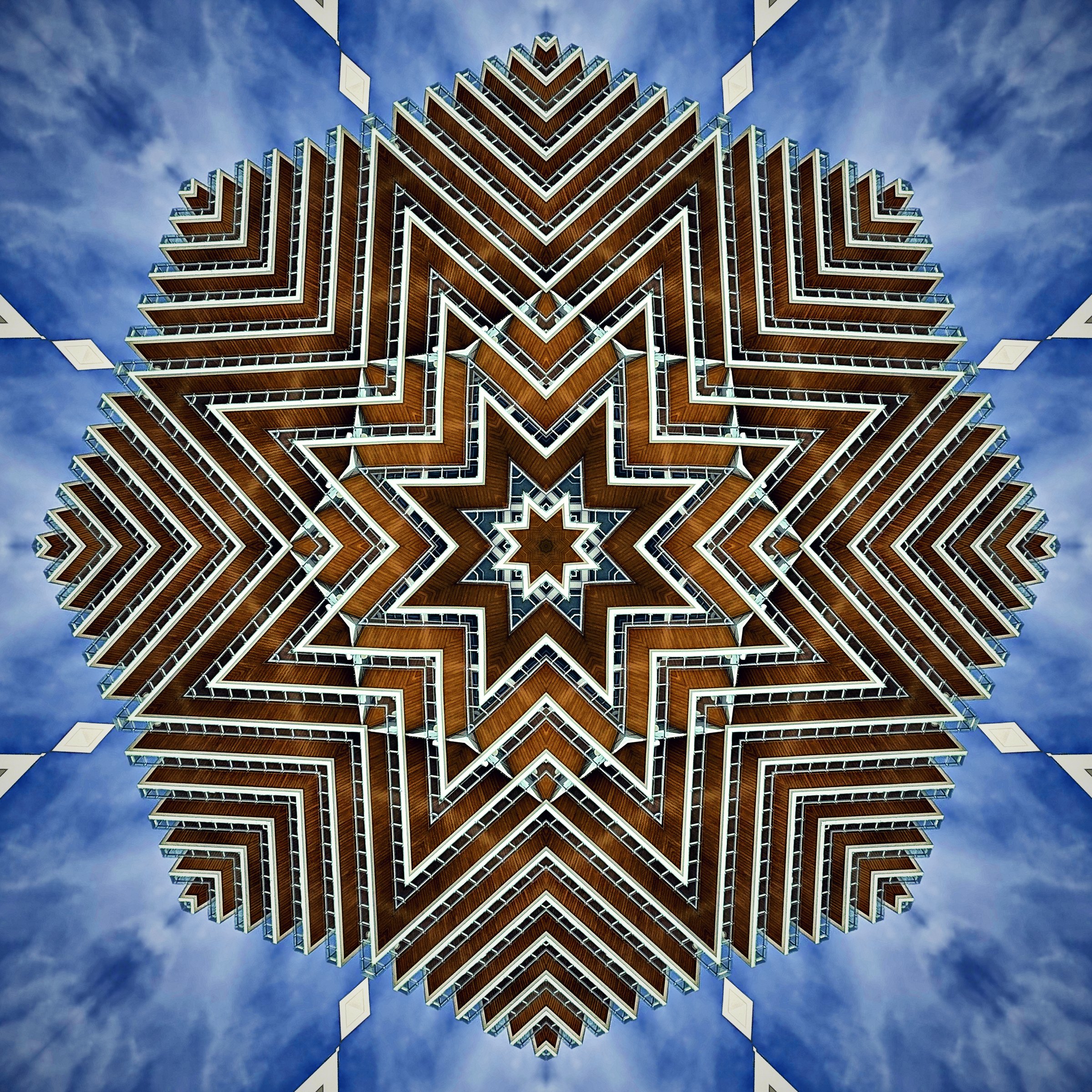 Starburst kaleidoscope of striped balconies against blue sky.