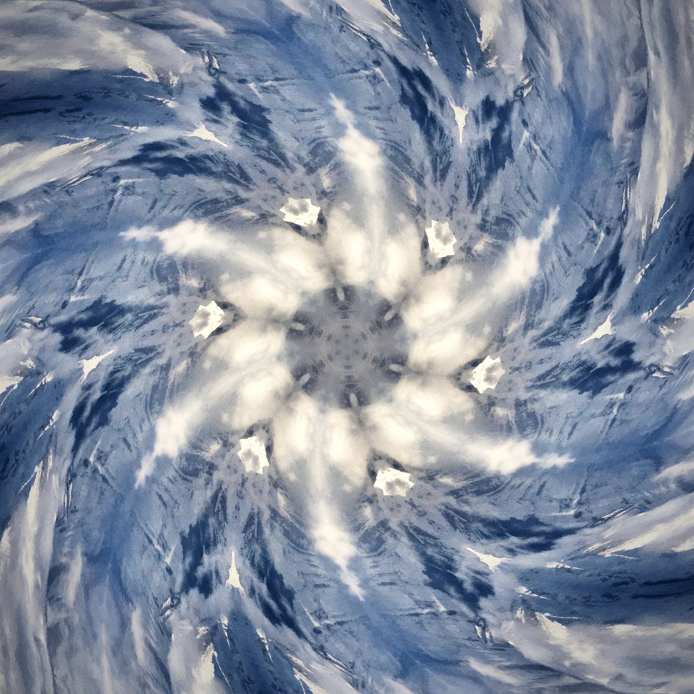 White clouds and blue sky twisting into a spiral like a turbine.