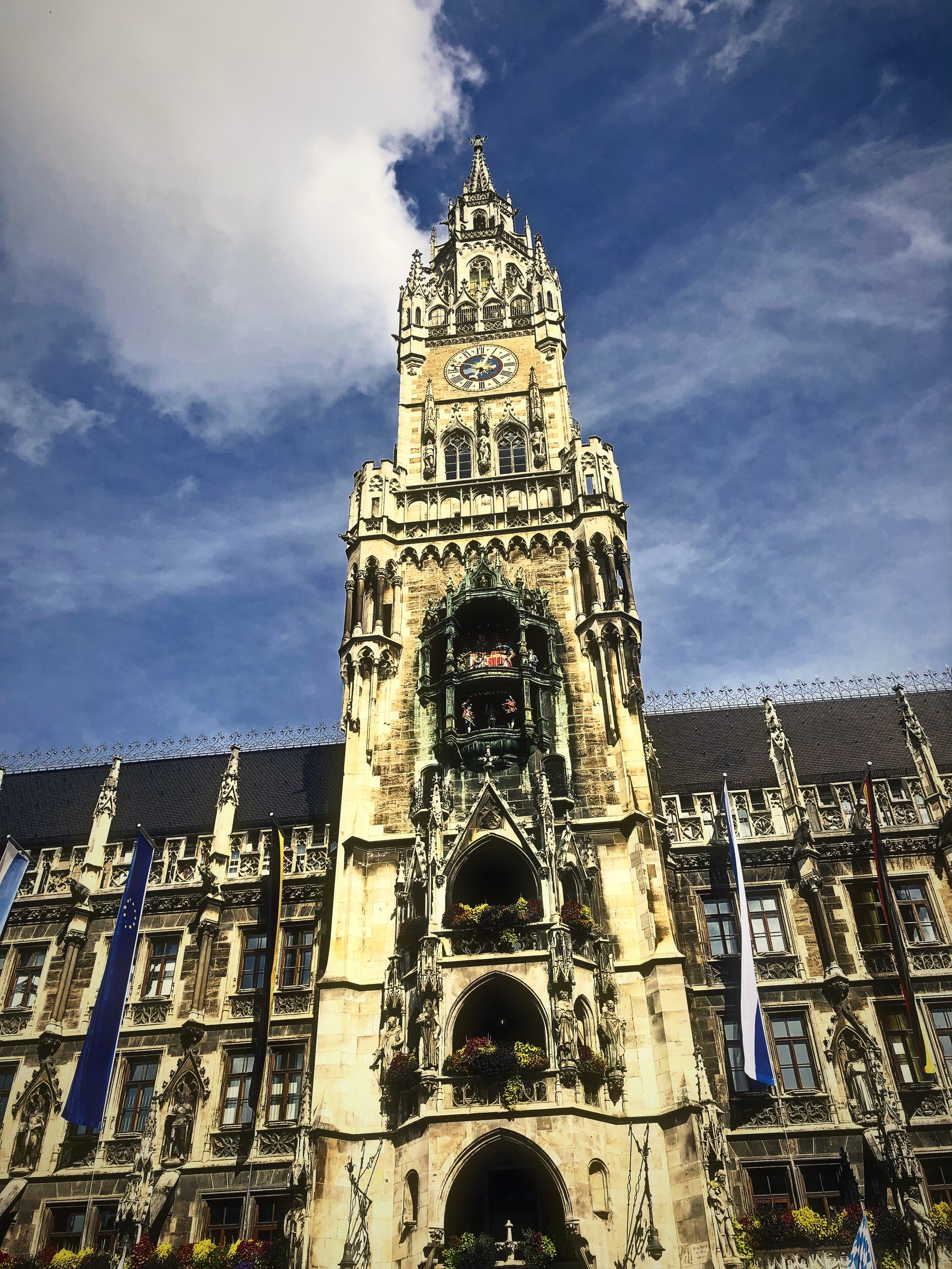 Ornate Gothic Revival town hall tower rising into a sky of moving cloud.