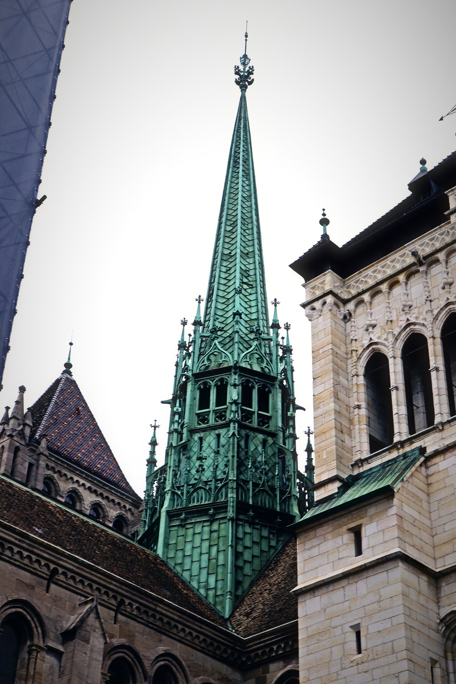 Green copper cathedral spire rising between old stone towers.