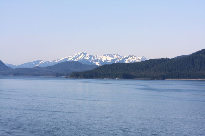 Snow-dusted mountains ringing a long blue fjord or lake.