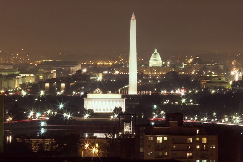 Washington Monument and Capitol dome lit at night across the city.