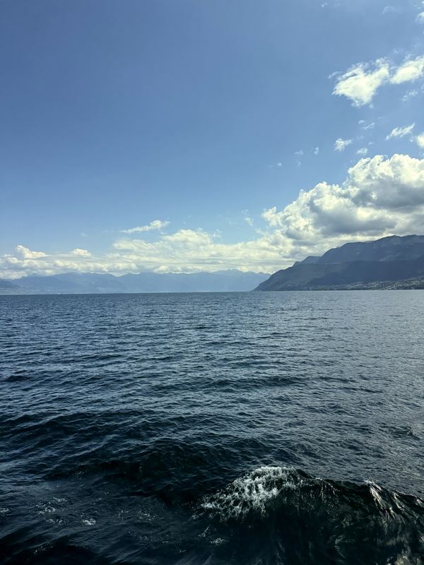 Dark choppy water looking toward hazy mountain coastline.