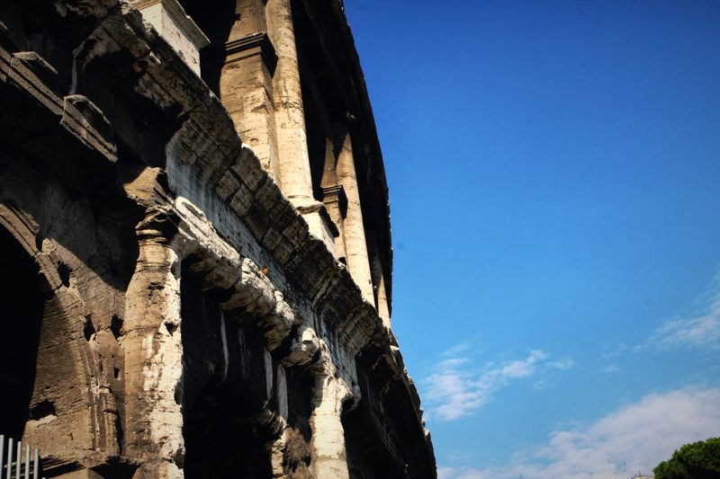 The jagged edge of the Colosseum's outer wall against the sky.