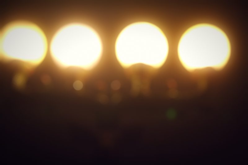 Four large glowing globes in a row against a dark background.