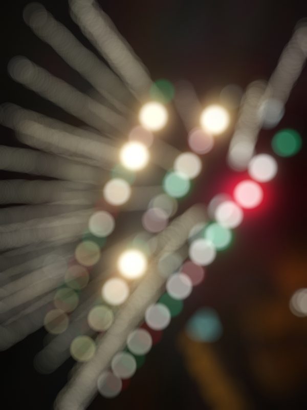 Diagonal streams of colored light orbs crossing the frame.