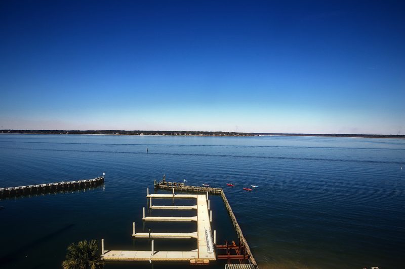 Empty floating dock slips on calm blue water under a clear gradient sky.