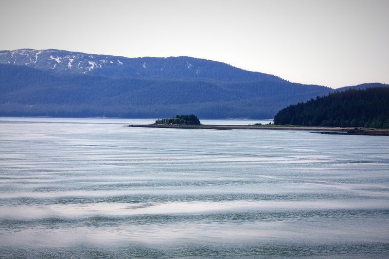 Pewter-grey water stretching to a long blue mountain ridge.