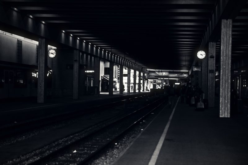 Long dark underground platform with a row of lights and columns.