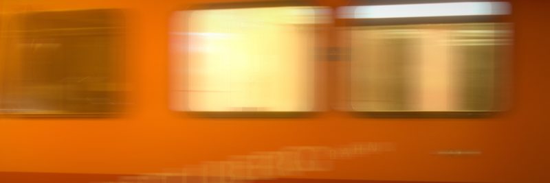 Long horizontal band of blurred orange with bright window lights.