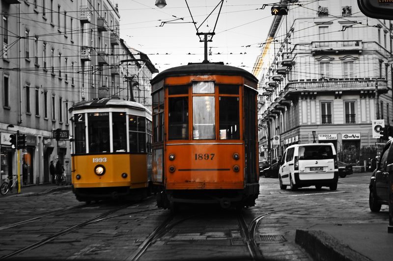 Black and white street with two vintage trams kept in bright orange.