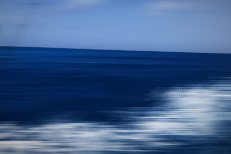 Horizontal bands of deep blue sea and white wave lines.