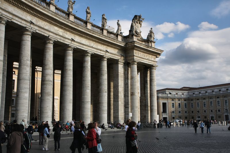 Bernini's colonnade at St Peter's Square with people walking past.