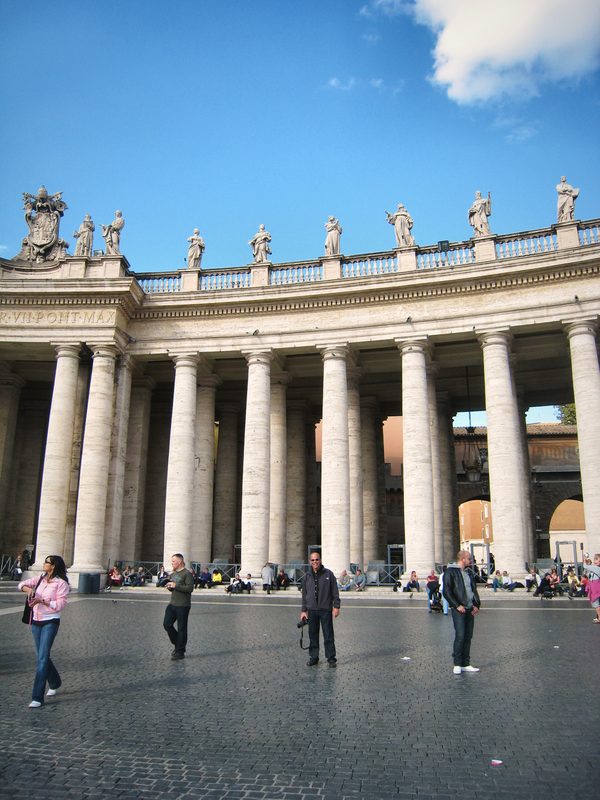 Bernini's colonnade with a few figures crossing the square.