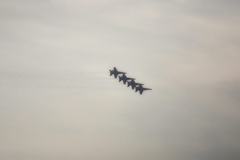 A tight formation of jets crossing a soft grey sky.