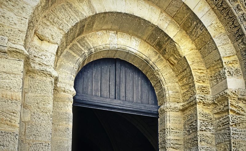 The carved concentric arches of a Romanesque church doorway in pale limestone.