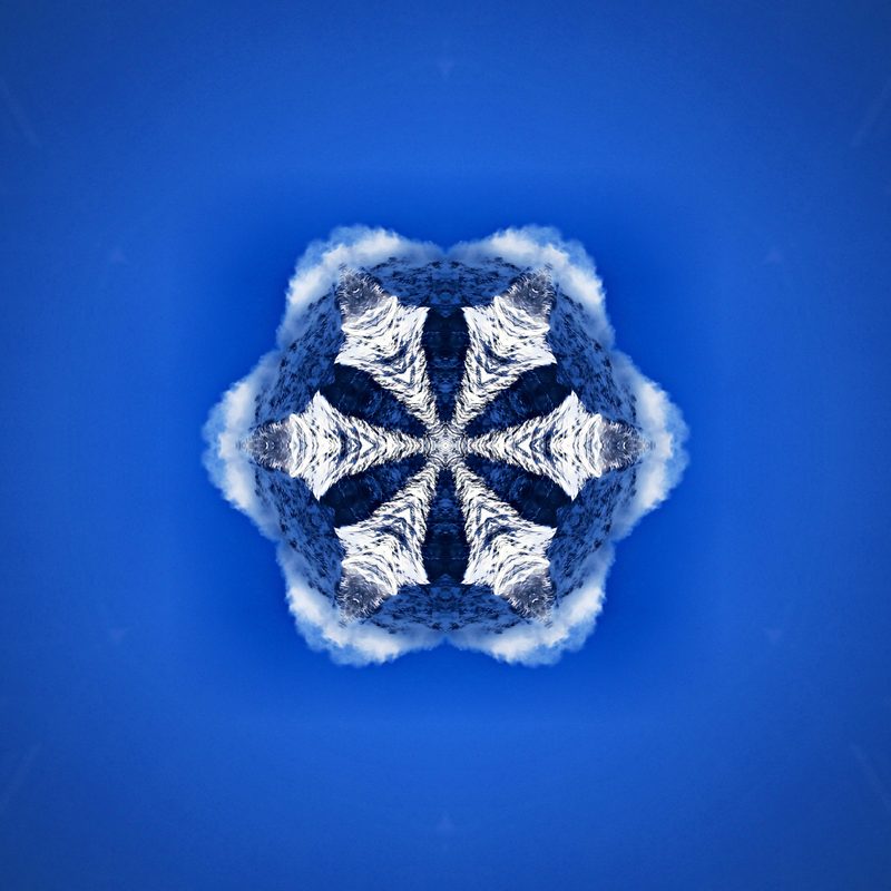 White snowflake shape on a deep blue field, made from mountain snow.
