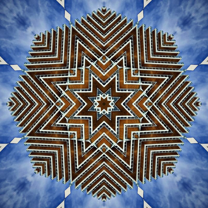 Starburst kaleidoscope of striped balconies against blue sky.