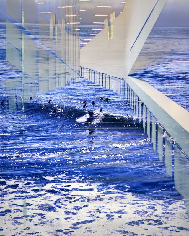 Stair railings and a walkway layered over deep blue surf.