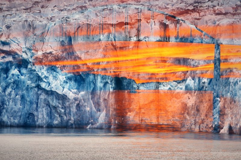 Glacier ice crossed by bands of orange sunset and bridge lines.