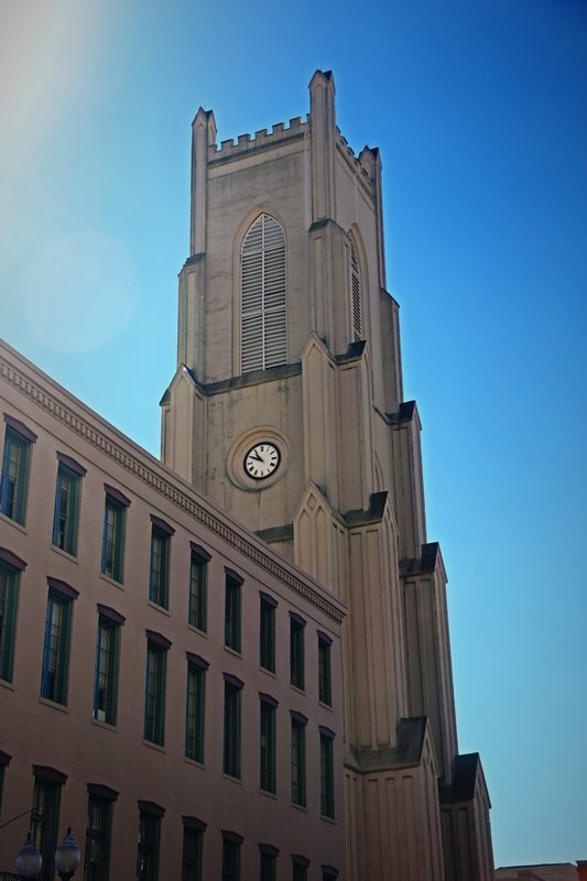 Tall stone tower with a clock climbing into a clear blue sky.