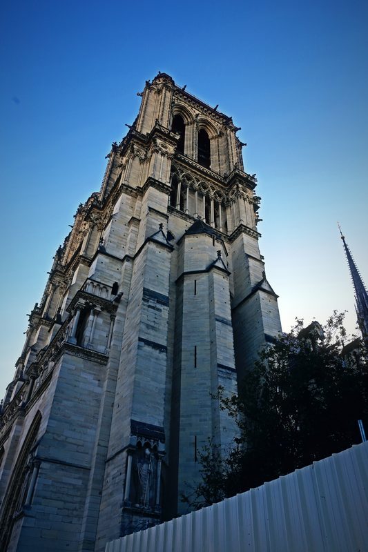 Gothic stone tower climbing into a clear blue sky.