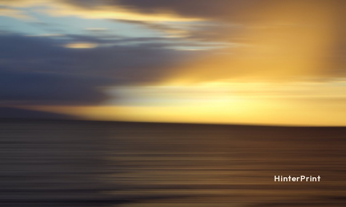 Front of the tag: blurred amber and blue light over a dark sea, with a small HinterPrint mark.