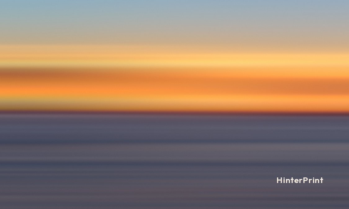 Front of the tag: bands of orange and gold sunset color over gray-blue water, with a small HinterPrint mark.